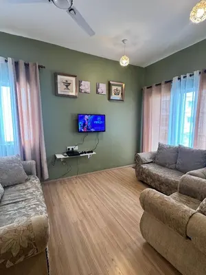 a living room with a couch and a flat screen tv at AYAAN Luxe Premium FIFA house with Free WiFi and Netflix in Tanah Rata