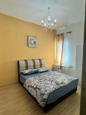 a bedroom with a bed and a chandelier at AYAAN Luxe Premium FIFA house with Free WiFi and Netflix in Tanah Rata