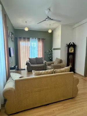 a living room with a couch and a clock at AYAAN Luxe Premium FIFA house with Free WiFi and Netflix in Tanah Rata