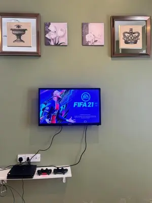 a flat screen tv on a wall with pictures at AYAAN Luxe Premium FIFA house with Free WiFi and Netflix in Tanah Rata
