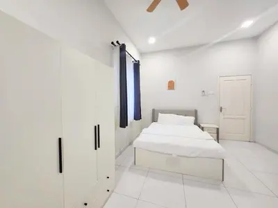 a white bedroom with a bed and a door at Ipoh Seri Botani 5br22 pax bbq mahjong in Kampong Kepayang