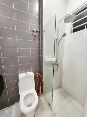 a bathroom with a toilet and a glass shower stall at Ipoh Seri Botani 5br22 pax bbq mahjong in Kampong Kepayang
