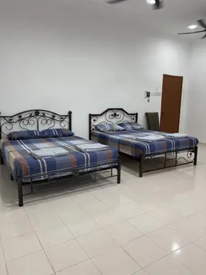 two beds are sitting in a room with at Bidor Homestay in Bidur