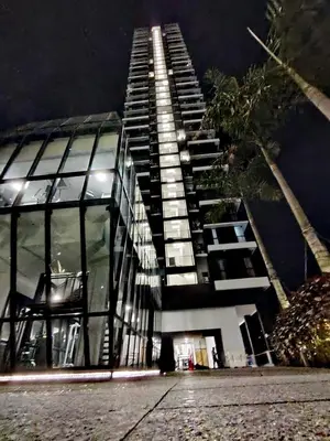 a tall building with a lot of windows at night at Luxury 3BR Seaview Getaway Perfect for 10 Guests A29 in George Town