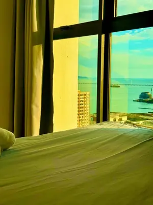 a bedroom with a large window with a view of the ocean at Modern 3BR w Panoramic Ocean Views Sleeps 10 A29 in George Town