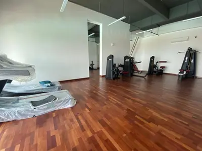 an empty gym with a hard wood floor and machines at Master Bedroom only in Bayan Lepas Share Space in Bayan Lepas
