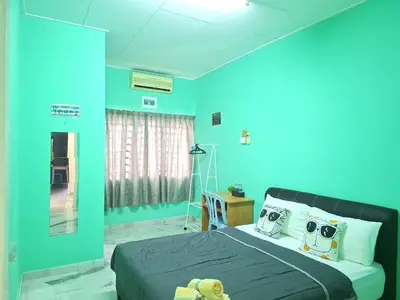 a bedroom with blue walls and a bed with pillows at Acacia Guesthouse by ZamanJa in Ipoh