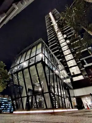 a glass building with lights in front of a tall building at Luxe 3BR Seaview Escape Sleeps 10 Prime Location A29 in George Town