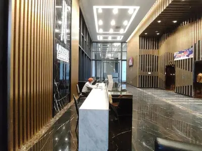 a man sitting at a long table in a lobby at 3BR Seaside Oasis Sleeps 10 Chic & Spacious A29 in George Town