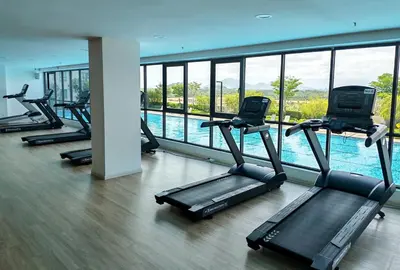 a gym with several treadmills and a swimming pool at Brand NEW Modern Cozy Retreats 3BR2B2P for 6 in Batu Kawan