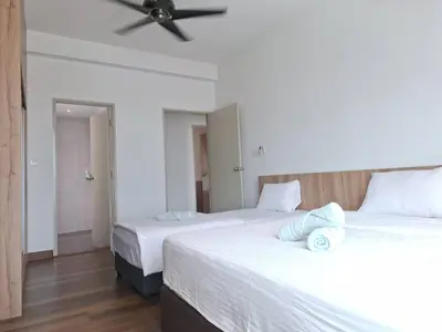 a bedroom with two beds and a ceiling fan at Cozy Homestay - Ipoh Garden in Ipoh