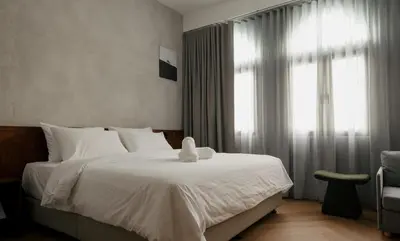 a bedroom with a large white bed with a window at Bishop House in George Town