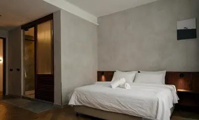 a bedroom with a large bed with white sheets at Bishop House in George Town