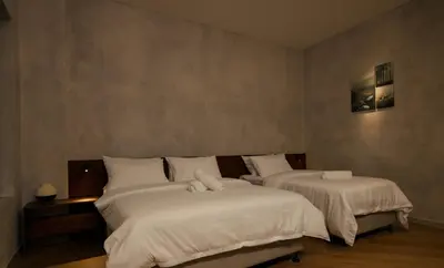 a bedroom with two beds with white sheets at Bishop House in George Town