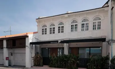 a large white building with windows on a street at Bishop House in George Town