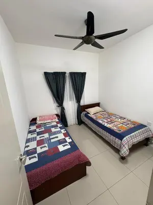 a bedroom with two beds and a ceiling fan at Homestay AtinAya in Tanjung Rambutan
