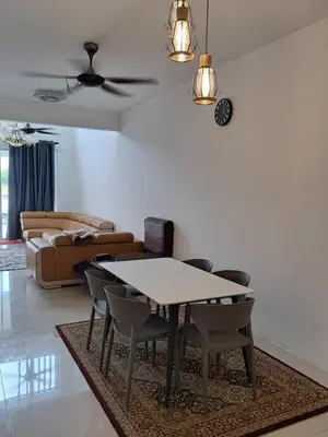 a living room with a table and chairs and a couch at Homestay AtinAya in Tanjung Rambutan