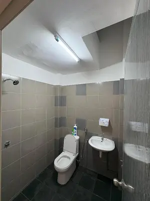 a bathroom with a toilet and a sink at Homestay AtinAya in Tanjung Rambutan