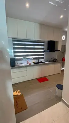 a kitchen with white cabinets and a red rug at 52 Homestay Pangkor in Pangkor