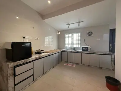 a large kitchen with a flat screen tv on a counter at Muji Homestay, 4 bedrooms, Few mins To Lean Tower by Mr Homestay in Teluk Intan