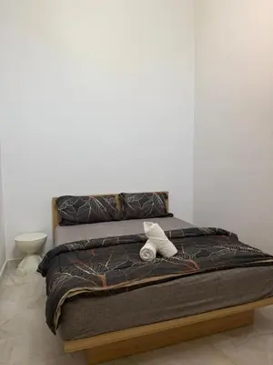 a bed with two towels on top of it at Muji Homestay, 4 bedrooms, Few mins To Lean Tower by Mr Homestay in Teluk Intan