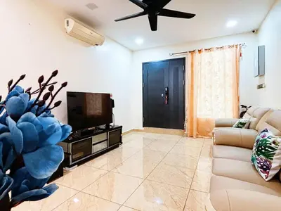 a living room with a couch and a flat screen tv at MiuMiu Homestay in Teluk Intan