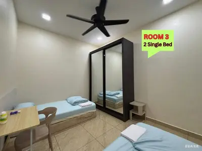a room with two twin beds and a ceiling fan at MiuMiu Homestay in Teluk Intan