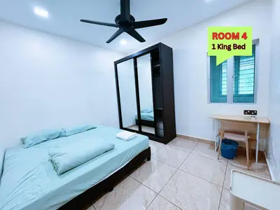 a bedroom with a bed and a desk and a ceiling fan at MiuMiu Homestay in Teluk Intan