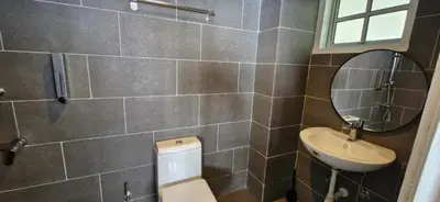 a bathroom with a toilet and a sink and a mirror at A3-6-1Silverpark LuxMountsin view Lifted unit in Bukit Fraser