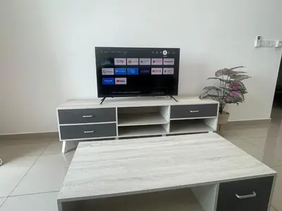 a flat screen tv sitting on top of a entertainment center at Happy Home Metropol - BM in Bukit Mertajam
