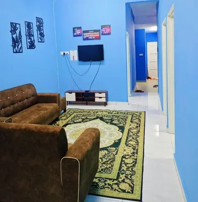a living room with a couch and a tv at The Batrisyia Homestay in TanjongMalim