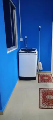 a blue room with a water tank in the corner at The Batrisyia Homestay in TanjongMalim