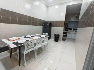 a kitchen with a table and chairs and a refrigerator at Hello Pangkor Home 73A - A Nest for 12 buddies in Pangkor