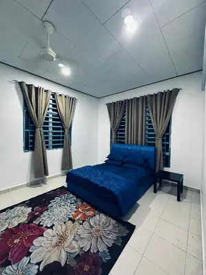 a bedroom with a blue bed and a rug at Madam Cottage Homestay in Sungai Petani