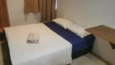 a white bed with two towels on top of it at NewTaunsHotel in Gua Sai