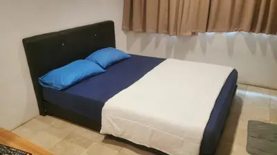a bed with blue pillows in a room at NewTaunsHotel in Gua Sai