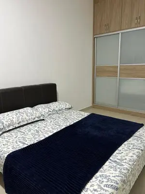 a bedroom with a bed with a blue rug on it at Ereens guest house Cameron highland in Brinchang