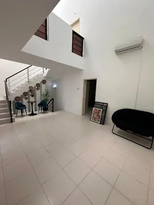 a living room with a couch and a staircase at Shamrock By Island Hospitality in Batu Ferringhi