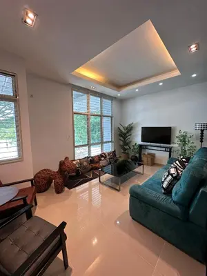 a living room with couches and a flat screen tv at Shamrock By Island Hospitality in Batu Ferringhi