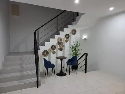a staircase with a table and two blue chairs at Shamrock By Island Hospitality in Batu Ferringhi