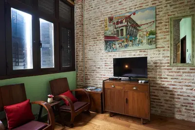 a living room with a flat screen tv on a brick wall at You Le Yuen in George Town
