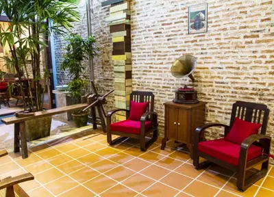 a room with two chairs and a table and a brick wall at You Le Yuen in George Town