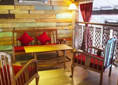 a room with two benches and a table on a balcony at You Le Yuen in George Town