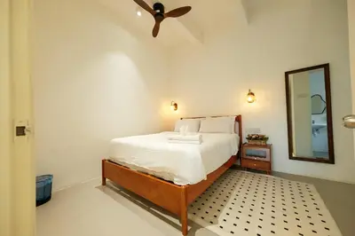 a bedroom with a bed with a ceiling fan and a mirror at Comfy Sofy-Bunny Vintage Penthouse in Tanah Rata