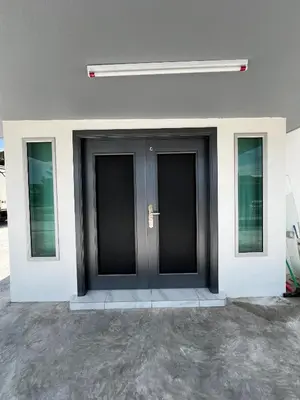 a black door on a building with three windows at Intan Pearl Homestay in Teluk Intan