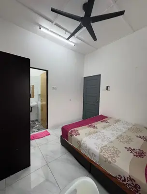 a bedroom with a bed and a ceiling fan at Intan Pearl Homestay in Teluk Intan