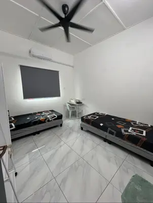 a room with two beds and a flat screen tv at Intan Pearl Homestay in Teluk Intan