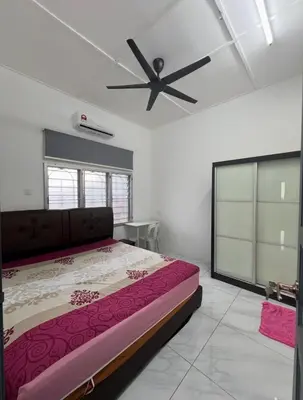 a bedroom with a bed and a ceiling fan at Intan Pearl Homestay in Teluk Intan