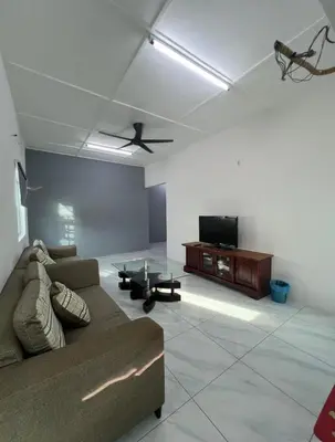 a living room with a couch and a flat screen tv at Intan Pearl Homestay in Teluk Intan