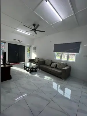 a living room with a couch and a ceiling fan at Intan Pearl Homestay in Teluk Intan